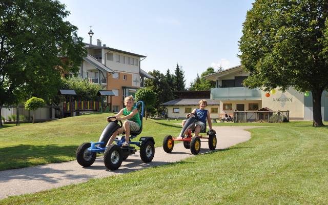 Zwei Jungs fahren Gokarts entlang einer Wiese