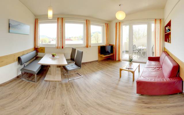 Unterkunft in Faak am See mit rotem Sofa und Essbereich
