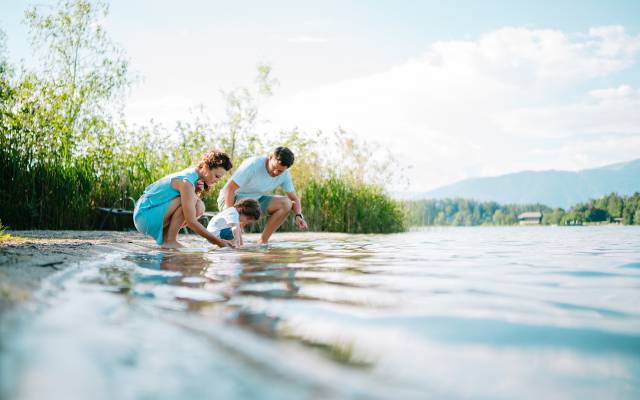 Familie planscht am Stand vom Faaker See