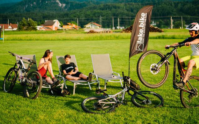 Gruppe von Leuten chillen auf der Liege im Grünen mit Ihren Bikes