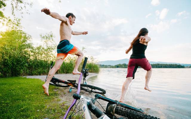 Mit dem Bike zum Faaker See - Personen springen ins Wasser
