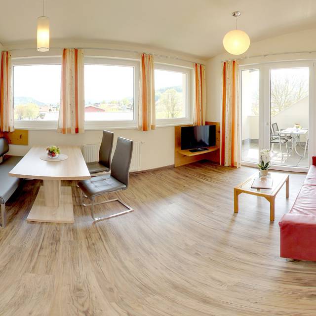 Unterkunft in Faak am See mit rotem Sofa und Essbereich