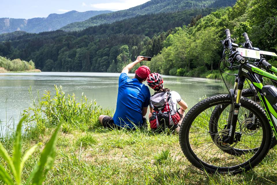 Paar in Radklamotten machen ein Selfi am See