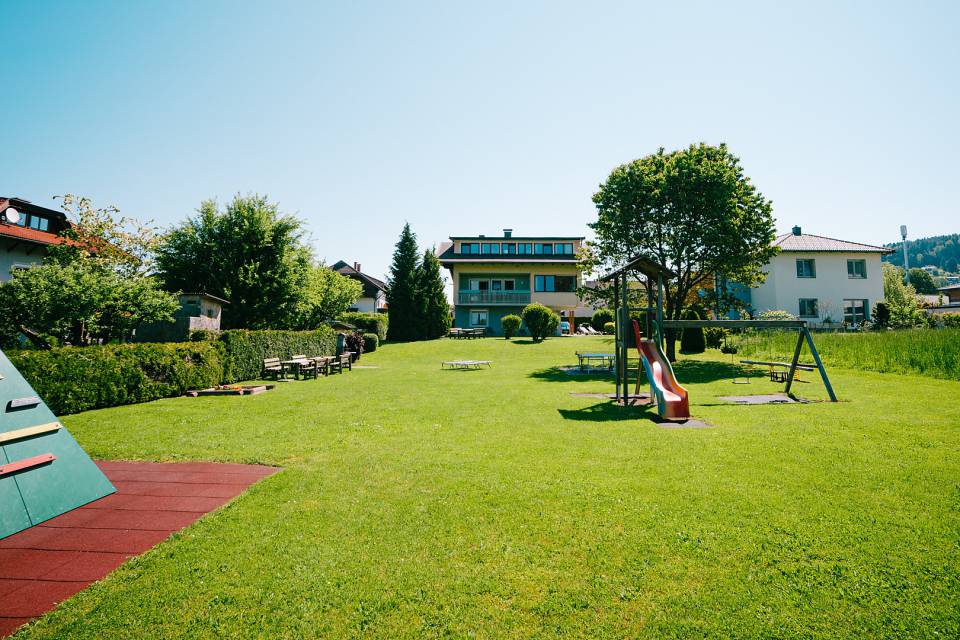Spielplatz mit Rutsche und großer Grasfläche zum Spielen